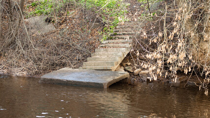 an old concrete pier with stairs on the river bank. view of the pier from the water. background picture. space for printing text.
