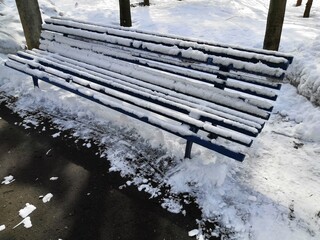 a snow-covered park bench in winter