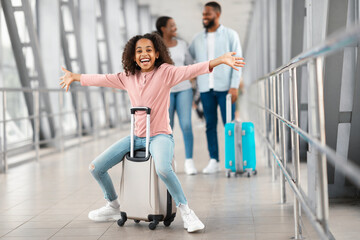 Fototapeta na wymiar Happy black girl playing and having fun in airport