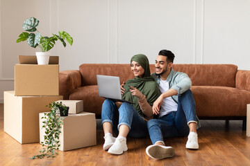 Happy man and woman using laptop after relocation