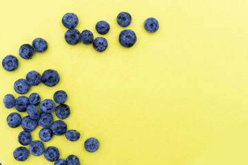 Tasty ripe blueberries on yellow background, flat lay