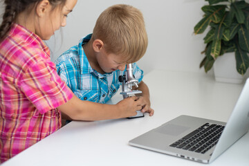 renewable energy, children, technology, science and people concept - kids or friends with laptop computer and microscope model