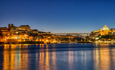 Fototapeta na wymiar View of Porto along the river Douro at dawn with the famous iron bridge in the back