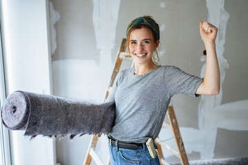 Elated young woman renovating her new home