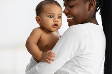 Happy African American mommy hugging her cute child