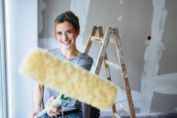 Playful happy young woman doing home improvements