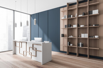 Reception interior desk with computers and shelf with books, window