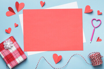 Love letter Valentine day concept. Blank paper mockup and paper hearts a gift on a blue background.