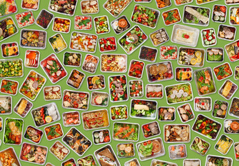 Naklejka premium Collection of foil takeaway containers with healthy food over green background