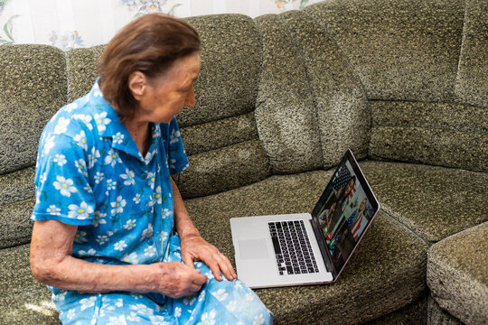 Very Old Woman Using Laptop Sitting In Her Sofa