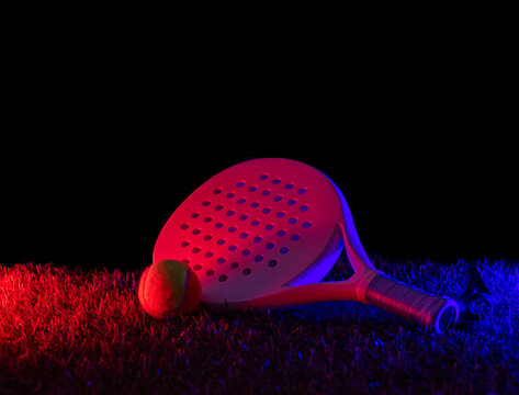 Beach and padel racket and ball on  grass court with neon lighting. Blue neon banner. Horizontal sport theme poster, greeting cards, headers, website and app