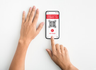 Woman showing smartphone with not valid digital passport for covid-19