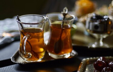 Black Turkish tea in lale with oriental sweets and dried fruits by candlelight 