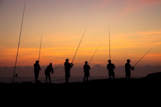 fisherman fishing in the ocean after sunset