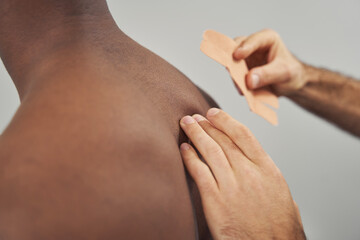 Physiatrist using kinesiology taping technique for pain relief