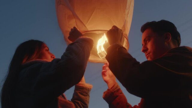 Coppia festeggia il nuovo anno con la lanterna cinese la notte in campagna
