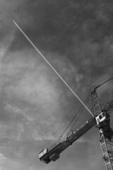 Crane with airplane leaving a trail