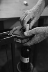 close up of hands of a person capping wine bottles