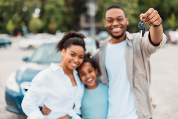 Fototapeta premium Joyful African American Family Showing New Car Key Standing Outdoors