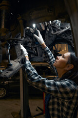 Responsible car mechanic running profound vehicle diagnostics