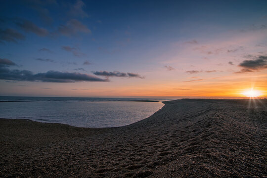 An aerial view of the sun setting over the coast at Shingle Street in Suffolk, UK