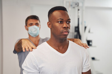 Tranquil young male patient undergoing spine examination