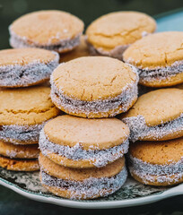 Plato lleno de alfajores de maicena rellenos de dulce de leche. Postre tipico de sudamerica