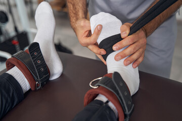 Obraz premium Qualified physical therapist preparing his patient for strength workout