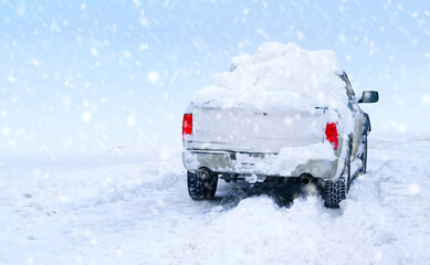 Winter snowstorm background with snow-covered pickup truck.