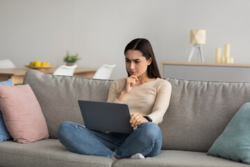 Fototapeta premium Online work, chat on social networks on computer sitting on sofa