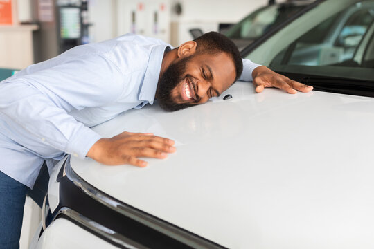 Happy African American Man Hugging Hood Of His New Car