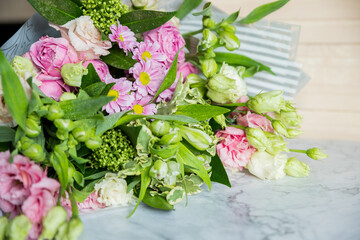 mock up bouquet of roses, daisies, lisianthus, chrysanthemums, unopened buds on table.white freesias, carnations. Floral background. Present for holidays.floral shop. Delivery fresh cut flower.