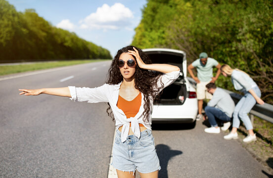 Millennial Lady Trying To Stop Passing Car, Asking For Help, Her Friends Fixing Broken Vehicle, Having Road Accident