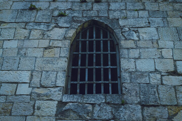 An old stone castle with iron bars on the windows.