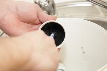 Clogged plastic water trap siphon cap cleaning under water with brush, home plumbing drainage...