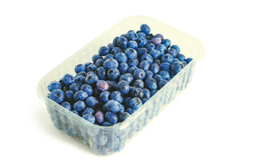Fresh ripe organic blueberries in transparent plastic box isolated on white background