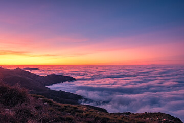 View over a cloud inversion over the Regino valley and Mediterranean sea in the Balagne region of Corsica at sunset with the Alps in the distance