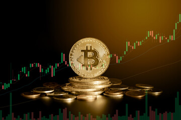 Close up of golden bitcoin coin on black background with trading graph