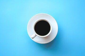 Top view of hot americano coffee in white coffee cup on blue background with copy space