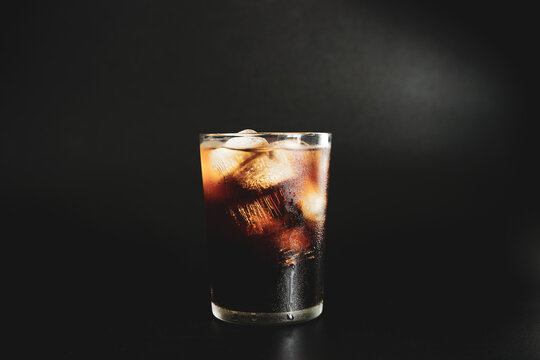 glass of iced americano coffee on black background