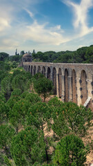 Obraz premium Pegoes aqueduct by the Castle and Convent of the Order of Christ in Tomar, Portugal. Aqueducts or water bridges are bridges constructed to convey watercourses across gaps such as valleys or ravines.