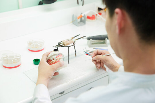 Dental technician doing partial dentures of acrylic resins in the lab.