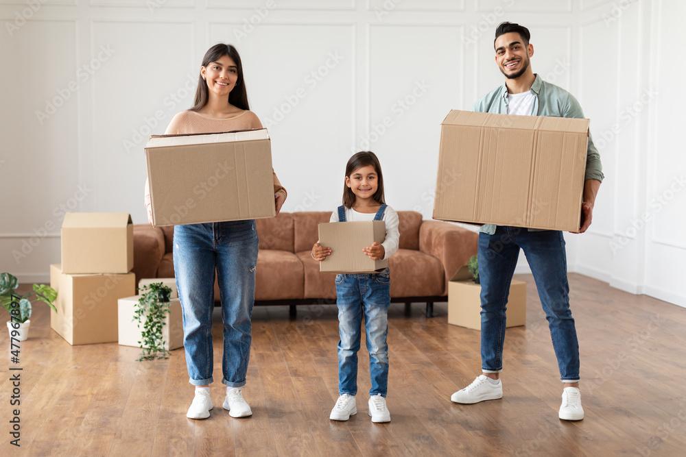 Sticker happy young family of three holding boxes in new flat