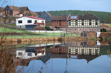 Wasserspiegelung einer Landschaft und eines Dorf