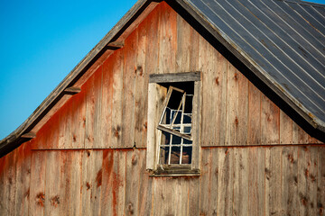 Fototapeta na wymiar Rustic aged barn siding and broken window