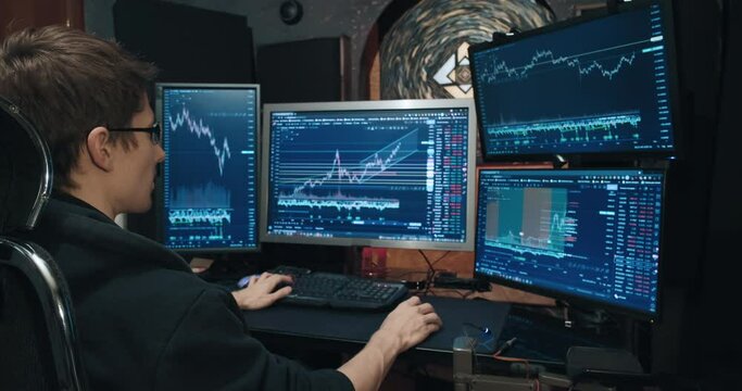 Man trader, freelancer on stock exchange trades options computer, charts of growth and fall of quotations on screen, home environment. Concept of playing on stock, futures and bonds trading exchange