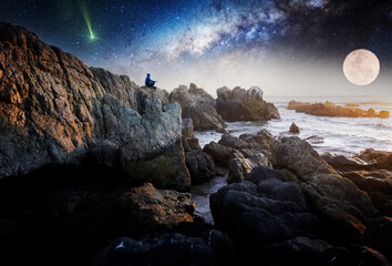 person meditating outdoors at night on top of the cliff with Milky Way and Moon background