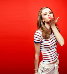 Fototapeta premium young pretty emitonal posing teenage girl on bright red background, happy smiling lifestyle people concept