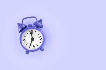 Purple alarm clock on purple background, very peri color of 2022