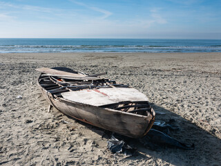 hull of a shipwrecked small sailboat on the beach - 477972648